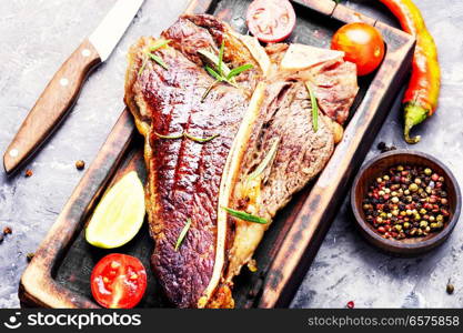 Grilled ribeye beef steak with spices on cutting board. Sirloin steak on cutting board