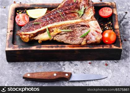 Grilled ribeye beef steak with spices on cutting board. Sirloin steak on cutting board