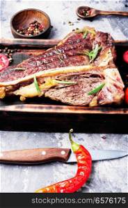 Grilled ribeye beef steak with spices on cutting board. Sirloin steak on cutting board