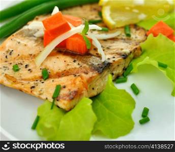 grilled salmon fillet with vegetables and lemon close up