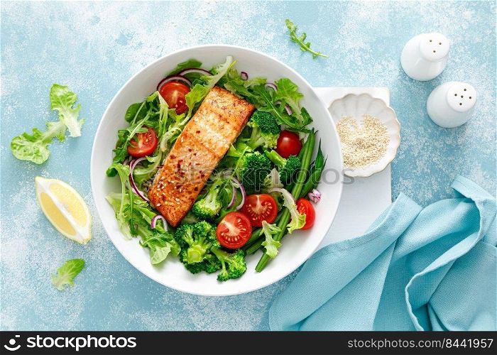 Grilled salmon fish fillet and fresh tomato vegetable salad with lettuce, arugula, broccoli and green beans. Healthy food, mediterranean diet