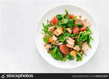 Grilled salmon salad with grapefruit, almonds and salad mix. Top view