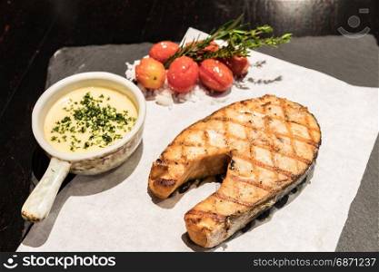 Grilled salmon steak served with grilled tomato ans sea salt