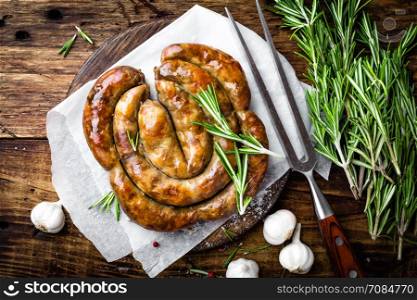 Grilled sausage on dark rustic wooden background, top view