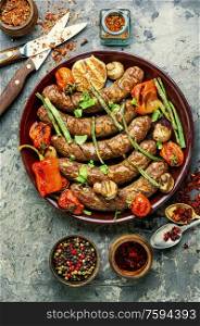 Grilled sausage with mushrooms and tomatoes.Fried bbq sausages with vegetables. Sausages fried with vegetable