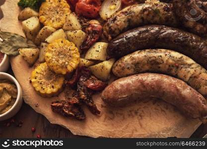 Grilled sausage with vegetables surved with sauce. Grilled sausage with vegetables