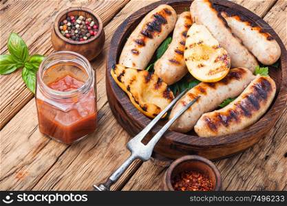 Grilled sausages and vegetables with sauce ketchup on wooden tray.Bbq food. Grilled sausages with vegetables