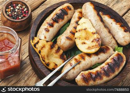 Grilled sausages fried with pear and.Autumn food.Grill menu. Grilled sausages on wooden board