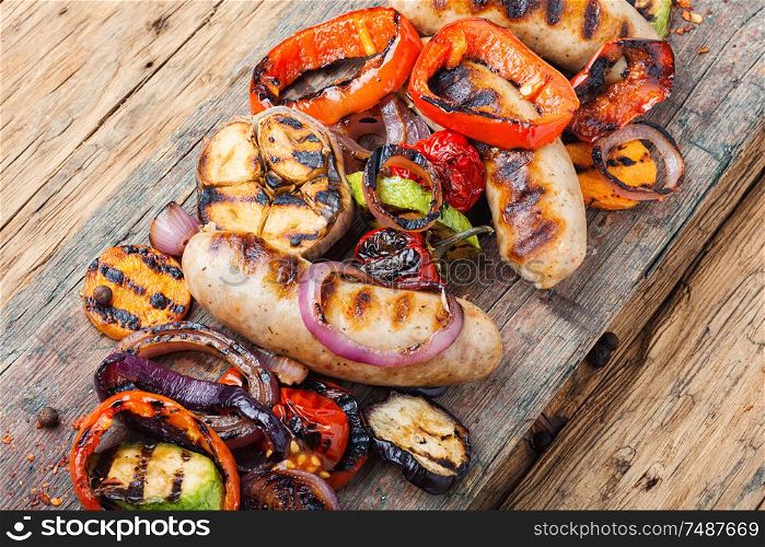 Grilled sausages fried with pear and vegetables. Autumn food.. Delicious sausages and vegetables