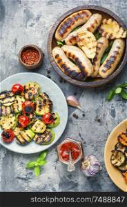 Grilled sausages fried with pear and vegetables. Autumn food.. Grilled sausages with vegetables