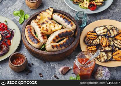 Grilled sausages fried with pear and vegetables. Autumn food.. Grilled sausages with vegetables