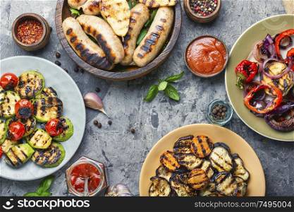 Grilled sausages fried with pear and vegetables.Autumn food.. Grilled sausages with vegetables