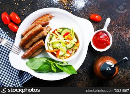 grilled sausages . grilled sausages with salad on white plate, stock photo