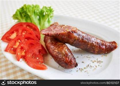 Grilled sausages with fries and vegetables