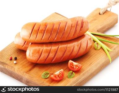 Grilled sausages with herbs and tomato on the cutting board