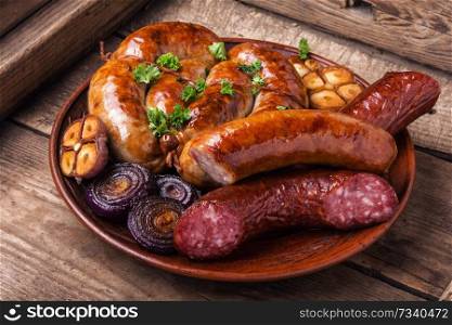 Grilled sausages with sauce ketchup on wooden table.Barbecue food. Grilled sausages on wooden table