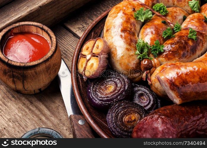 Grilled sausages with sauce ketchup on wooden table. Grilled sausages on wooden board