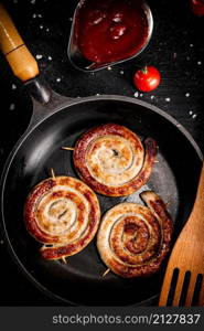 Grilled sausages with tomato sauce. On a black background. High quality photo. Grilled sausages with tomato sauce.