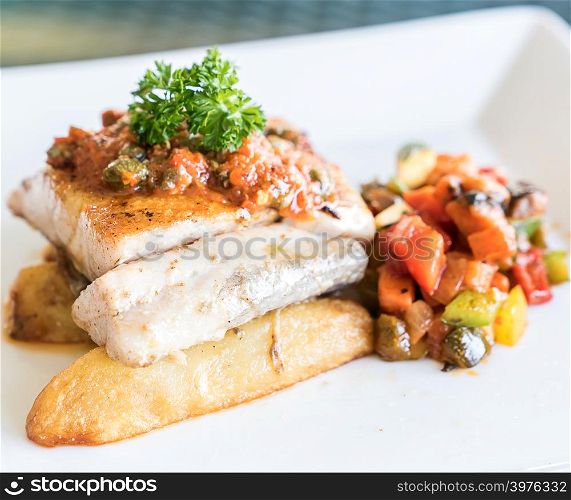 Grilled seabass fish with grilled vegetable on fries