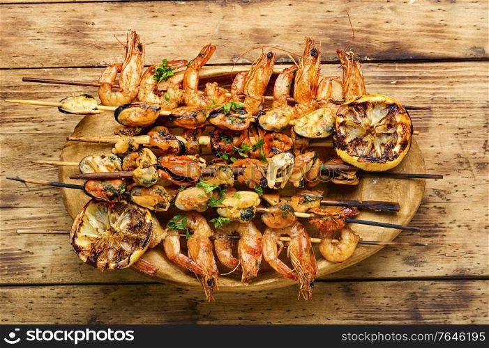 Grilled shrimp and mussels on wooden stick. Grilled shrimps and mussels
