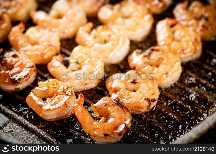 Grilled shrimp in a frying pan. On a rustic background. High quality photo. Grilled shrimp in a frying pan.