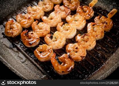 Grilled shrimp in a frying pan. On a rustic background. High quality photo. Grilled shrimp in a frying pan.