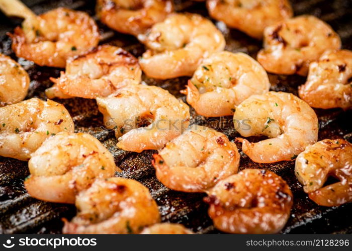 Grilled shrimp in a frying pan. On a rustic background. High quality photo. Grilled shrimp in a frying pan.