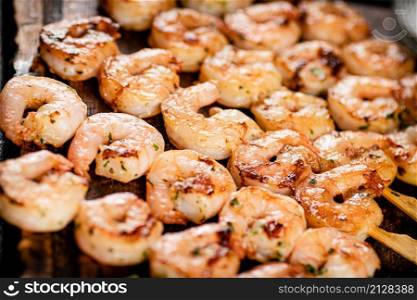 Grilled shrimp on a wooden cutting board. High quality photo. Grilled shrimp on a wooden cutting board.