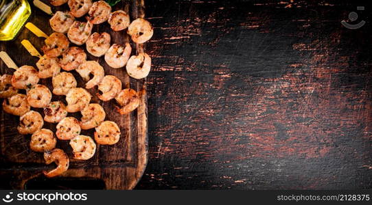 Grilled shrimp on skewers. On a rustic dark background. High quality photo. Grilled shrimp on skewers. On a rustic dark background.