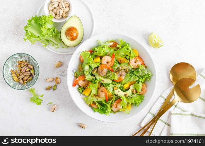 Grilled shrimp salad with avocado, mango, lettuce and pistachios, dressed with lime. Healthy food. Ketogenic diet. Top view.