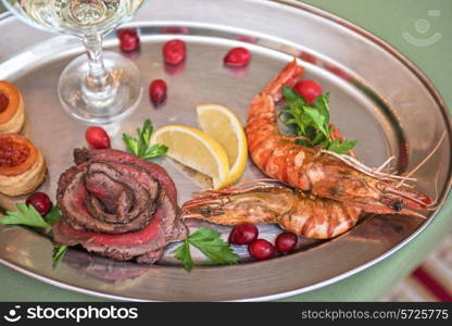 Grilled shrimps and beef meat on a plate