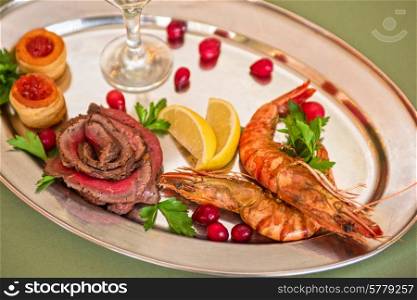 Grilled shrimps and beef meat on a plate. Grilled shrimps and beef meat