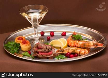 Grilled shrimps and beef meat on a plate. Grilled shrimps and beef meat