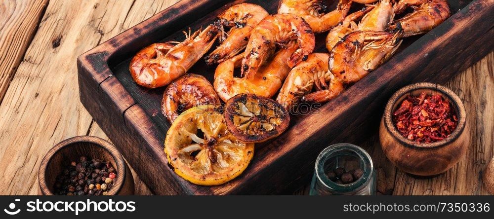 Grilled shrimps on a wooden kitchen board. Delicious seafood.Barbecue srimps prawns. Grilled large prawns