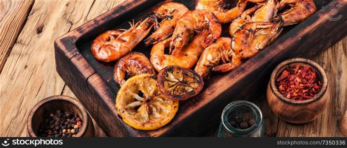 Grilled shrimps on a wooden kitchen board. Delicious seafood.Barbecue srimps prawns. Grilled large prawns