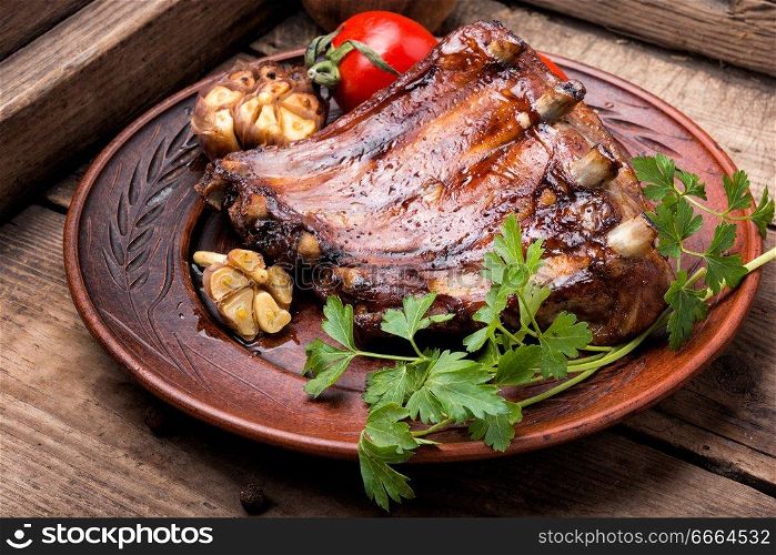 Grilled sliced barbecue pork rib on a rustic wooden background. Tasty roasted ribs
