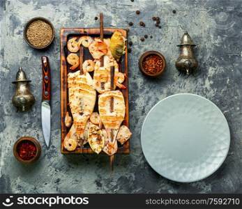 Grilled squid skewers on a kitchen board.Grilled calamari. Grilled squid on a skewer