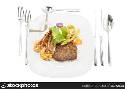 Grilled steak and shrimp served on mashed potatoes with vegetables.