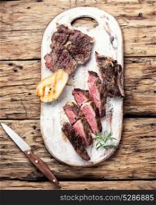 grilled steak in pear sauce. Grilled steak sliced on a cutting board