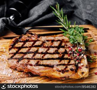 Grilled striploin sliced steak on cutting board over wooden table