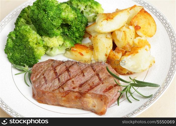 Grilled striploin steak (new york steak) served with crushed garlic potatoes and boiled broccoli