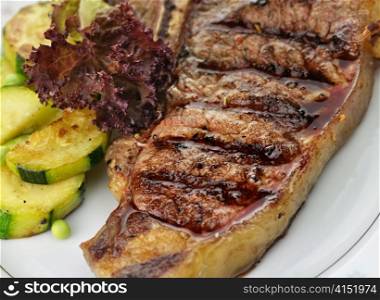 grilled t-bone steak and vegetables , close up