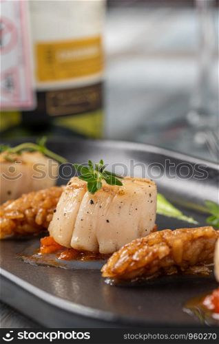 Grilled tasty scallops served on black plate. Grilled tasty Scallops
