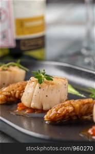 Grilled tasty scallops served on black plate. Grilled tasty Scallops