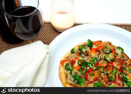 Grilled teriyaki chicken with red bell pepper, garlic, mild jalapeno pepper, broccoli, tomato, shrarp cheddar and fresh parmesan cheese and a glass of red wine.. Gourmet Chicken And Veggie Pizza
