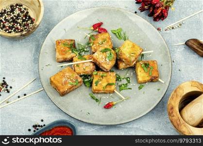 Grilled tofu cheese skewers and sesame seeds on the plate.Homemade healthy vegetarian dishes. Skewers with tasty tofu cheese