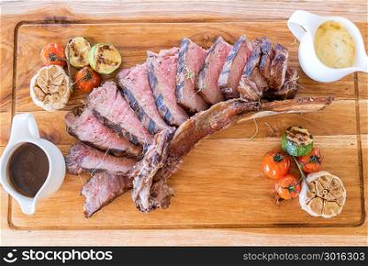 Grilled tomahawk steak on wooden plate