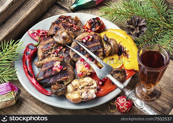 Grilled veal with vegetables to the Christmas table.Christmas food.Veal in pomegranate sauce.. Christmas grilled meat