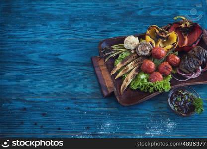 Grilled vegetable on a blue wooden background. Grilled vegetable at plate