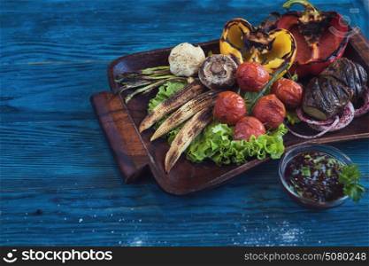 Grilled vegetable on a blue wooden background. Grilled vegetable at plate